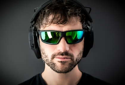Man wearing Eclipse sunglasses with green mirror lenses and ShellShock earmuffs, front view
